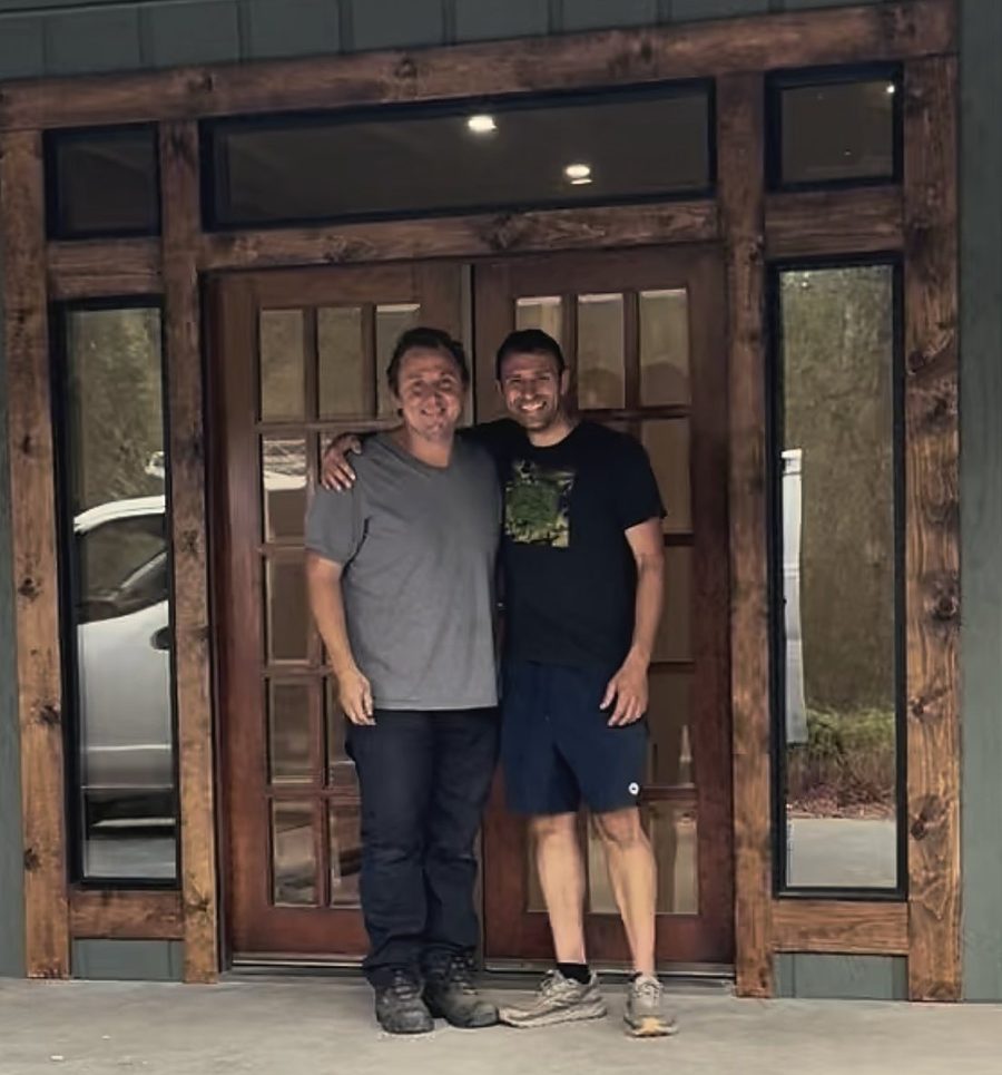 Daniel and Russ standing together at the front door of a finished home